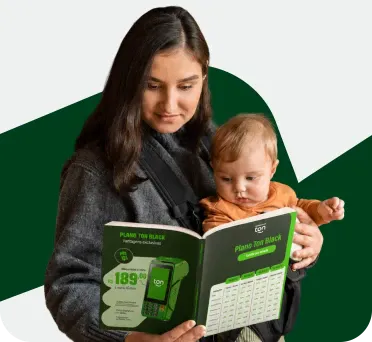 Mulher com um bebê no colo lendo o catálogo de planos Ton Black