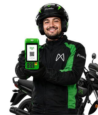 Entregador da Mottu sorrindo, exibindo a maquininha Ton em frente à sua moto